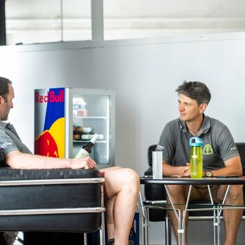 2 Männer beim Austausch am Tisch sitzend